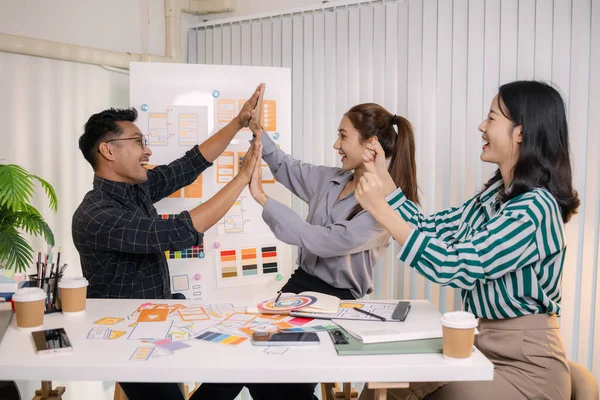 UX / UI tasarımcıları bir yaratıcı atölye sırasında uygulama geliştirme için arayüz fikirlerini test etmek ve geri bildirim alışverişinde bulunmak, takım çalışmasını ve yenilikçi tasarım düşüncesini vurgulamak için işbirliği yaparlar.