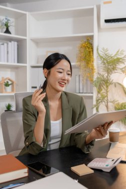 Modern bir ofiste çalışan genç bir iş kadını, bilgiyi değerlendirir ve profesyonel bir zihniyetle günlük görevlere odaklanır, üretkenliği, sorumluluğu ve modern kurumsal yaşam tarzını temsil eder.