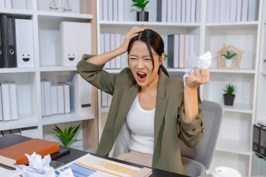 Ağır iş baskısı ile uğraşan stresli iş kadını, raporları incelerken duygusal tepki verirken ve son teslim tarihleriyle yüzleşirken, işyeri stresi ve modern mesleki zorlukları vurguluyor.