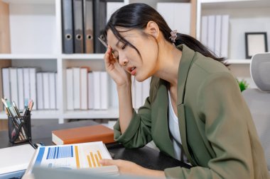 Ağır iş baskısı ile uğraşan stresli iş kadını, raporları incelerken duygusal tepki verirken ve son teslim tarihleriyle yüzleşirken, işyeri stresi ve modern mesleki zorlukları vurguluyor.