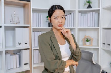 Bir ofis ortamında bağımsız çalışan, planlama ve günlük sorumluluklara odaklanan, kararlılık, profesyonellik ve dengeli bir çalışma tarzı gösteren iş kadını.