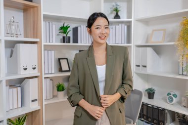 Bir ofis ortamında bağımsız çalışan, planlama ve günlük sorumluluklara odaklanan, kararlılık, profesyonellik ve dengeli bir çalışma tarzı gösteren iş kadını.