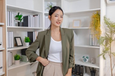 Bir ofis ortamında bağımsız çalışan, planlama ve günlük sorumluluklara odaklanan, kararlılık, profesyonellik ve dengeli bir çalışma tarzı gösteren iş kadını.