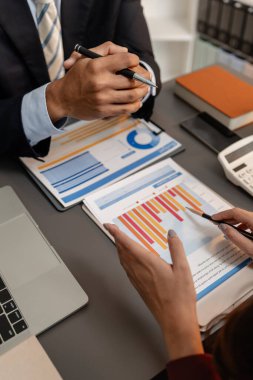 Profesyonellerin finansal tabloları gözden geçirdiği ve görüşleri paylaştığı, stratejik planlamayı ve modern ofis ortamında işbirlikçi karar vermeyi vurguladığı bir iş toplantısı sahnesi.