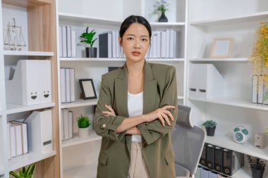 Modern bir ofiste çalışan genç bir iş kadını, bilgiyi değerlendirir ve profesyonel bir zihniyetle günlük görevlere odaklanır, üretkenliği, sorumluluğu ve modern kurumsal yaşam tarzını temsil eder.