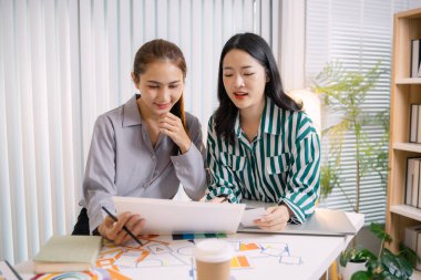 UX / UI tasarımcıları son tasarım projelerini takıma sunar, uygulama arayüzü ekranlarını gösterir ve profesyonel yaratıcı ofis ortamında kullanıcı deneyimi stratejilerini açıklar.