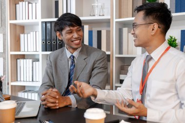 Bir şirket toplantısında satış performansı ve yönetim stratejilerini tartışan iş adamları, sonuçları ve iş büyümesini iyileştirmek için analiz, karar verme ve işbirliği üzerinde duruluyor.