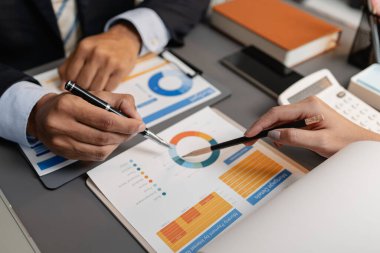 Profesyonellerin finansal tabloları gözden geçirdiği ve görüşleri paylaştığı, stratejik planlamayı ve modern ofis ortamında işbirlikçi karar vermeyi vurguladığı bir iş toplantısı sahnesi.