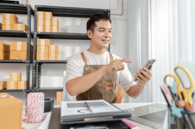 Çevrimiçi ticareti yöneten genç girişimci, paketleri hazırlıyor ve e-ticaret operasyonlarıyla çalışıyor, dijital pazarı, başlangıç büyümesini ve modern perakende stratejisini temsil ediyor.