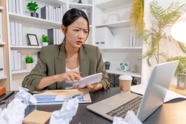 Ağır iş baskısı ile uğraşan stresli iş kadını, raporları incelerken duygusal tepki verirken ve son teslim tarihleriyle yüzleşirken, işyeri stresi ve modern mesleki zorlukları vurguluyor.