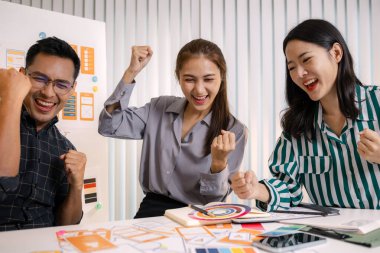 UX / UI tasarımcıları bir yaratıcı atölye sırasında uygulama geliştirme için arayüz fikirlerini test etmek ve geri bildirim alışverişinde bulunmak, takım çalışmasını ve yenilikçi tasarım düşüncesini vurgulamak için işbirliği yaparlar.