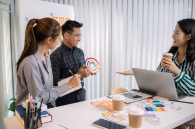 UX / UI tasarımcıları bir yaratıcı atölye sırasında uygulama geliştirme için arayüz fikirlerini test etmek ve geri bildirim alışverişinde bulunmak, takım çalışmasını ve yenilikçi tasarım düşüncesini vurgulamak için işbirliği yaparlar.