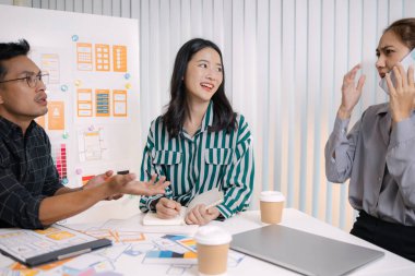 UX / UI tasarımcıları son tasarım projelerini takıma sunar, uygulama arayüzü ekranlarını gösterir ve profesyonel yaratıcı ofis ortamında kullanıcı deneyimi stratejilerini açıklar.