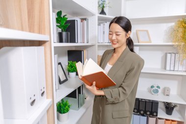 İş kadını çağdaş bir ofiste çalışmaya, sorumlulukları ve günlük işleri yönetmeye, profesyonelliği, kariyer büyümesini ve modern çalışma hayatını sembolize etmeye odaklandı..