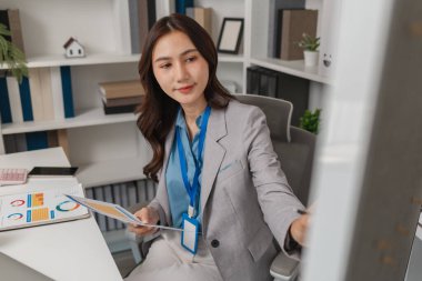 Modern bir ofiste veri sunan ve raporları açıklayan profesyonel iş kadını, etkili yönetim ve takım kararlarını desteklemek için görüşleri paylaşıyor ve stratejiyi tartışıyor.