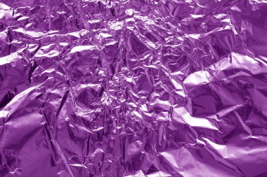 Shiny purple foil texture background, pattern of violet wrapping paper with crumpled and wavy.