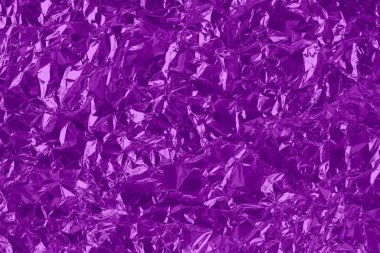 Shiny purple foil texture background, pattern of violet wrapping paper with crumpled and wavy.