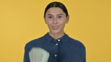 Dolar Tutan Genç Latin Kadın, Sarı Arkaplan 