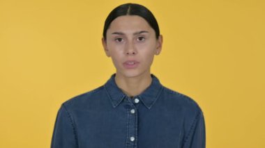 Genç Latin Kadın Başparmakları Aşağı, Sarı Arkaplan 