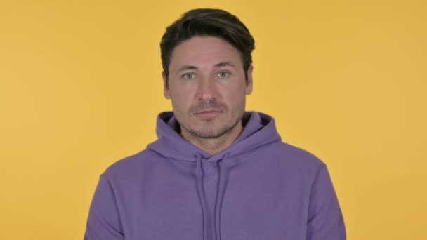 Young Man Looking at Camera, Yellow Background — Stock Video