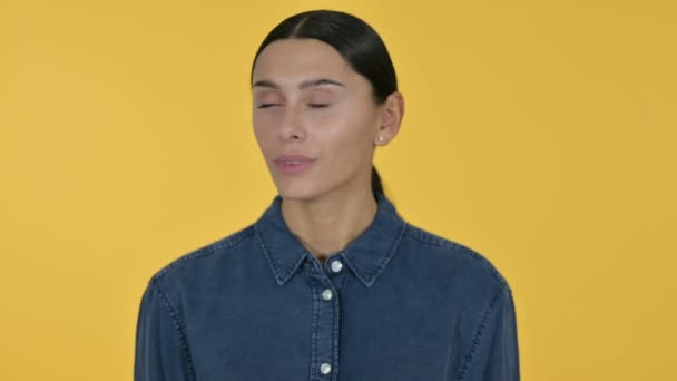 Νεαρή λατινική γυναίκα κεφάλι κούνημα δεν υπάρχει σημάδι, κίτρινο φόντο — Αρχείο Βίντεο