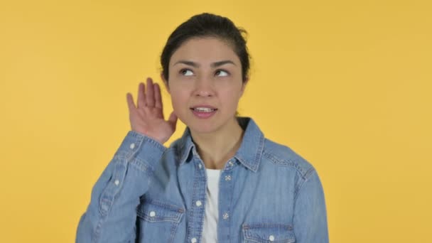 若いインド人女性が耳を傾け、黄色の背景 — ストック動画