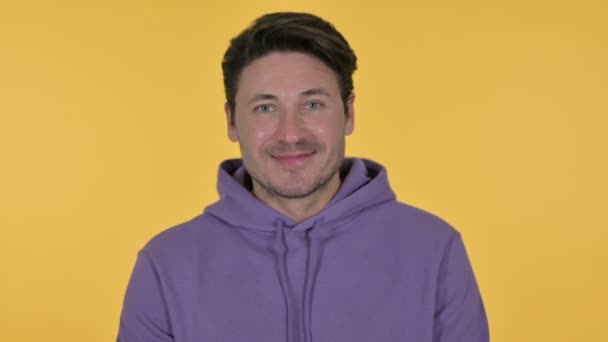 Young Man Smiling at Camera, Yellow Background — Stock Video