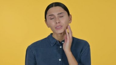 Diş ağrısı olan genç Latin Kadın, Sarı Arkaplan