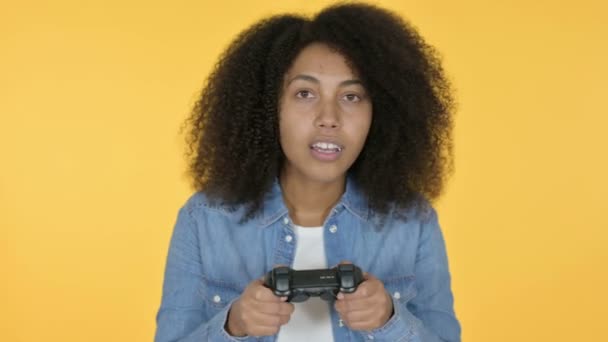 Joven mujer africana jugando videojuego, fondo amarillo — Vídeo de stock