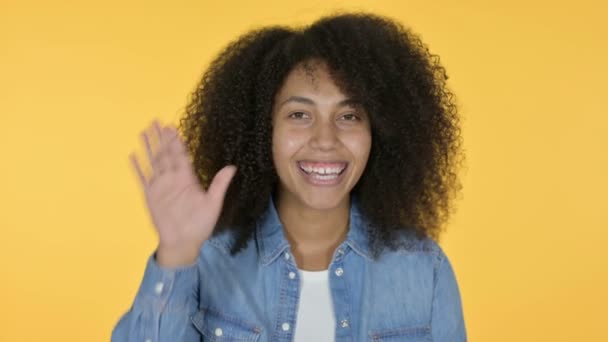 Jovem mulher africana acenando, fundo amarelo — Vídeo de Stock