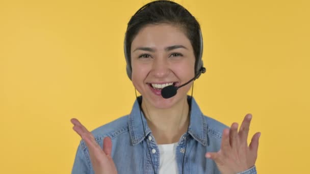 Veselý mladý indický žena mluvící na sluchátka, žluté pozadí — Stock video