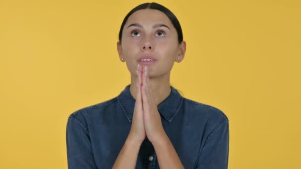 Young Latin Woman Praying, Yellow Background — Stock Video