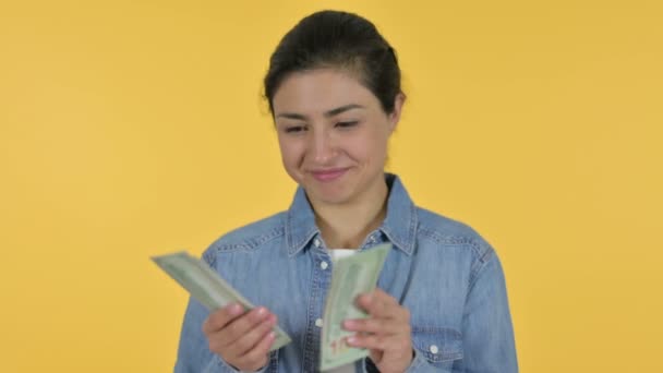 Gelukkig jong indiaans vrouw tellen dollars, gele achtergrond — Stockvideo