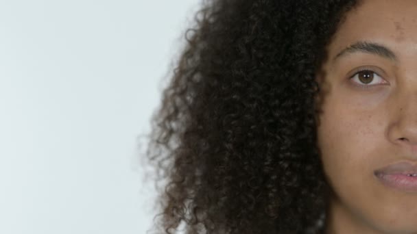 Hälften ansikte ung afrikansk kvinna, vit bakgrund — Stockvideo