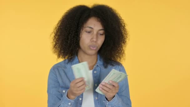 Joven mujer africana contando dólares, fondo amarillo — Vídeo de stock