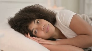 Yatakta uzanmış Kameraya bakan Afrikalı Kadın