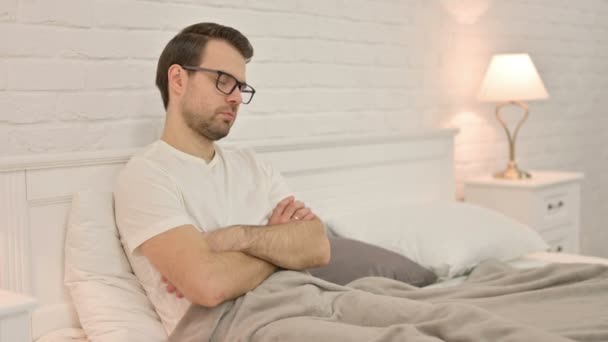 Schläfriger junger Mann schläft im Bett ein — Stockvideo