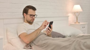 Genç Adam Yatakta Akıllı Telefon Kullanıyor 