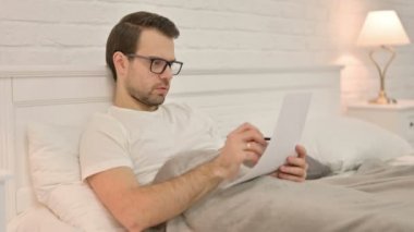 Yatakta Evrak İşi Yapan Çalışkan Genç Adam 