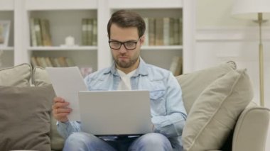 Evrakları Evde Dizüstü bilgisayarda çalışan Erkek Tasarımcı