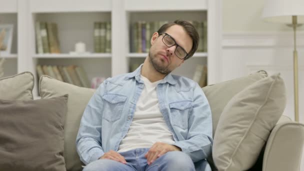 Cansado joven casual durmiendo en el sofá — Vídeos de Stock