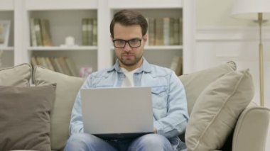 Evde dizüstü bilgisayarda kaybolan genç adam tepki veriyor.