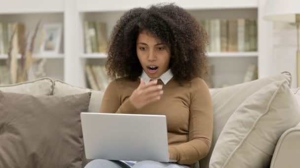 Młoda Afrykanka z laptopem reaguje na porażkę na kanapie — Wideo stockowe