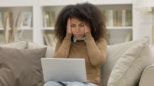 Junge Afrikanerin mit Laptop hat Kopfschmerzen auf Sofa — Stockvideo