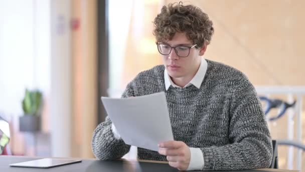 Junger kreativer junger Mann reagiert auf Verlust von Dokumenten bei der Arbeit — Stockvideo