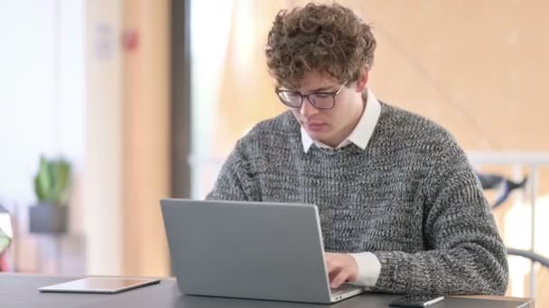 Jonge creatieve jonge man met laptop toont duimen naar beneden — Stockvideo