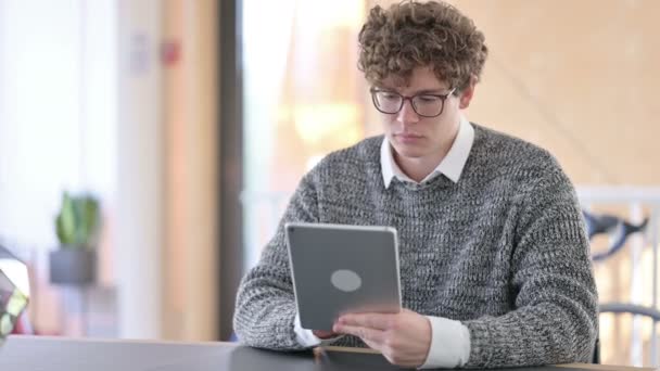 Konzentrierter kreativer junger Mann mit digitalem Tablet bei der Arbeit — Stockvideo