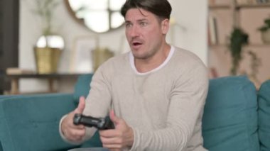 Orta yaşlı adam evdeki video oyununda kaybına tepki veriyor 