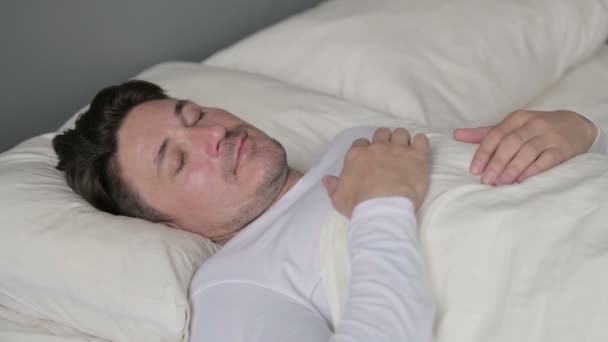 Un bărbat liniștit de vârstă mijlocie se trezește din somn în pat — Videoclip de stoc