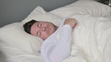 Uykusuzluk çeken orta yaşlı adam yatakta uyuyamıyor. 